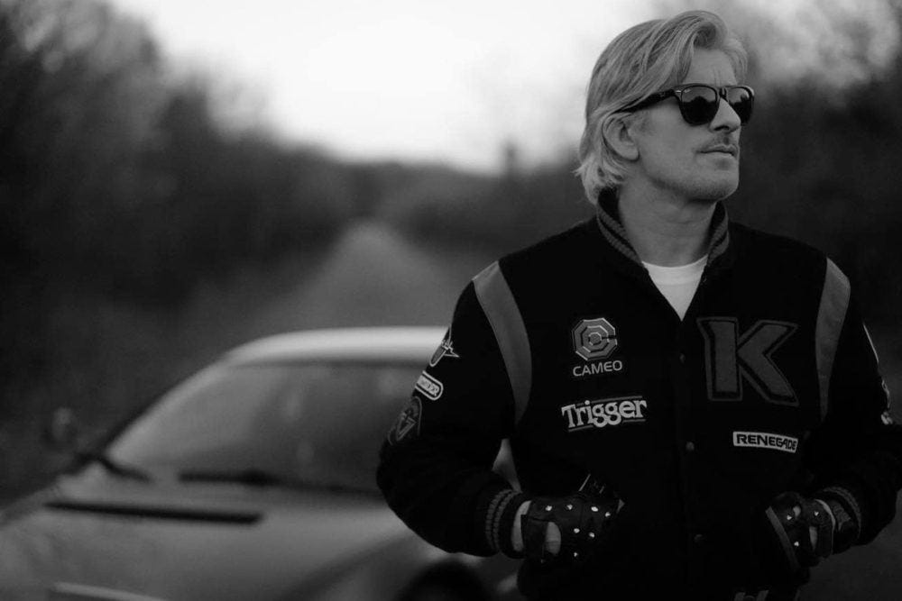 Kavinsky, photographed on an open road in a varsity jacket
