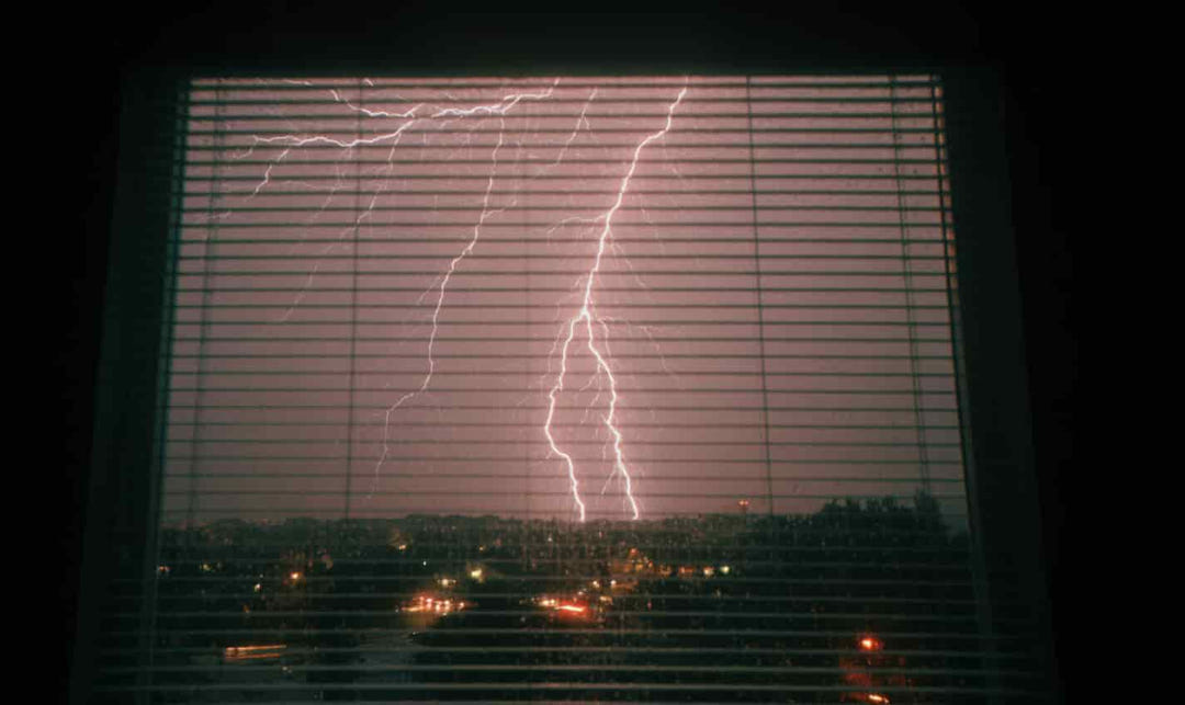 The Magic of Watching Thunderstorms Through Plastic Blinds