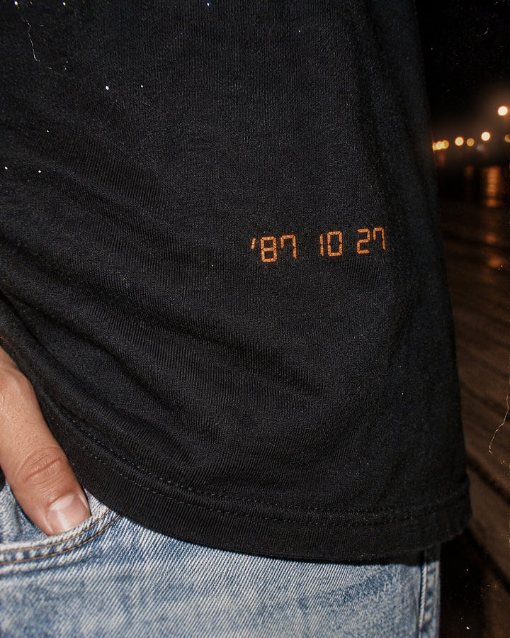 Close up of the orange 87 10 27 date stamp on the Date Stamp Tee 1987
