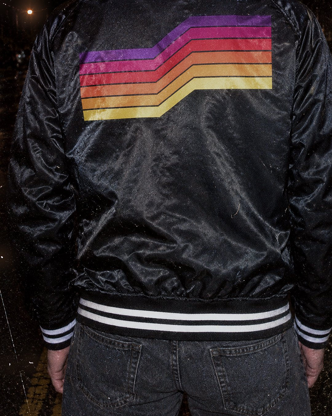 Back of the Downshift Varsity 1985 on a wet boulevard at night
