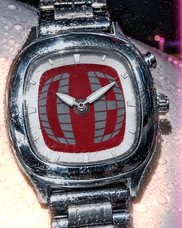 Red Grid Watch 1985 close up on a wet car hood at night
