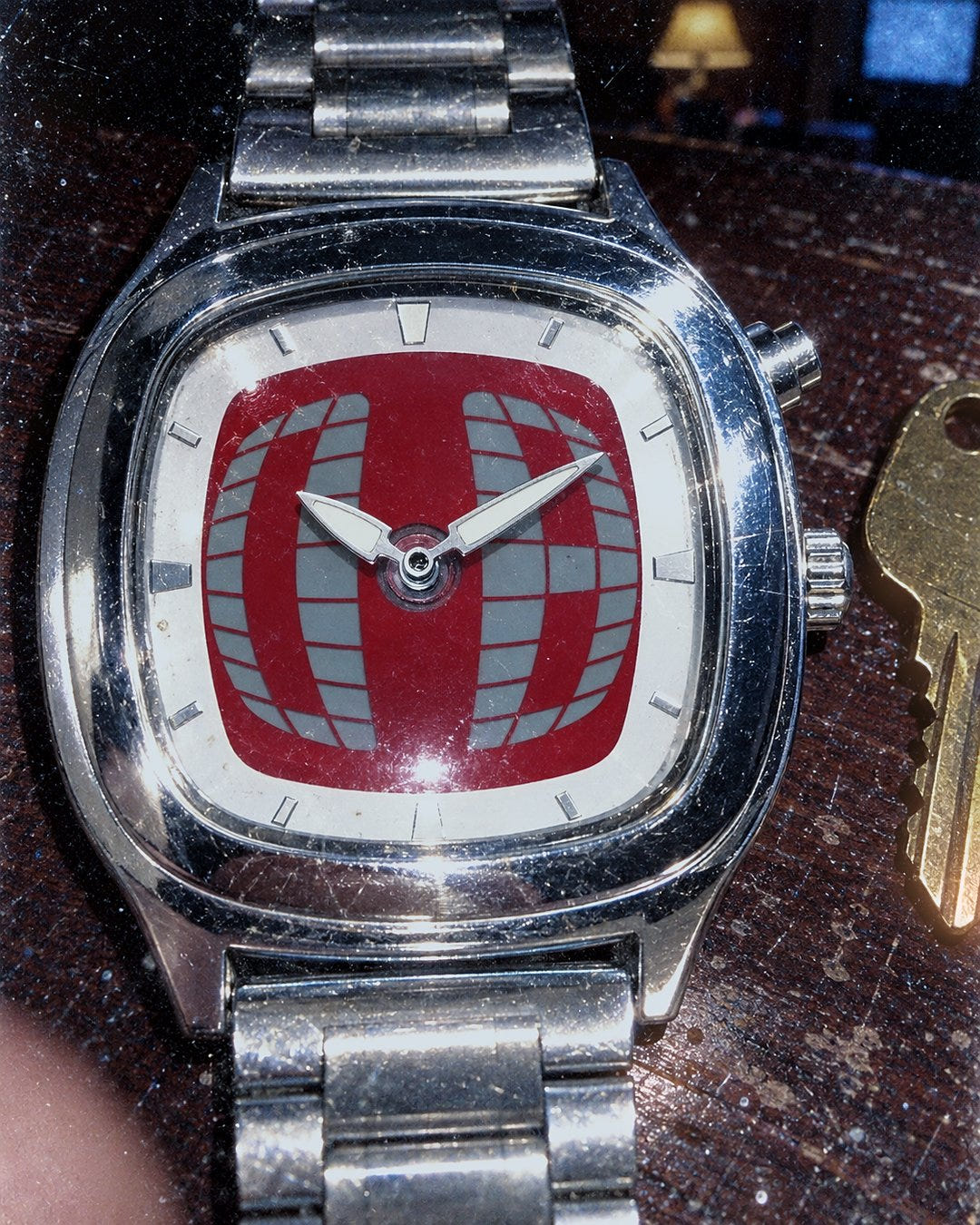 Red Grid Watch 1985 on a motel nightstand next to a room key